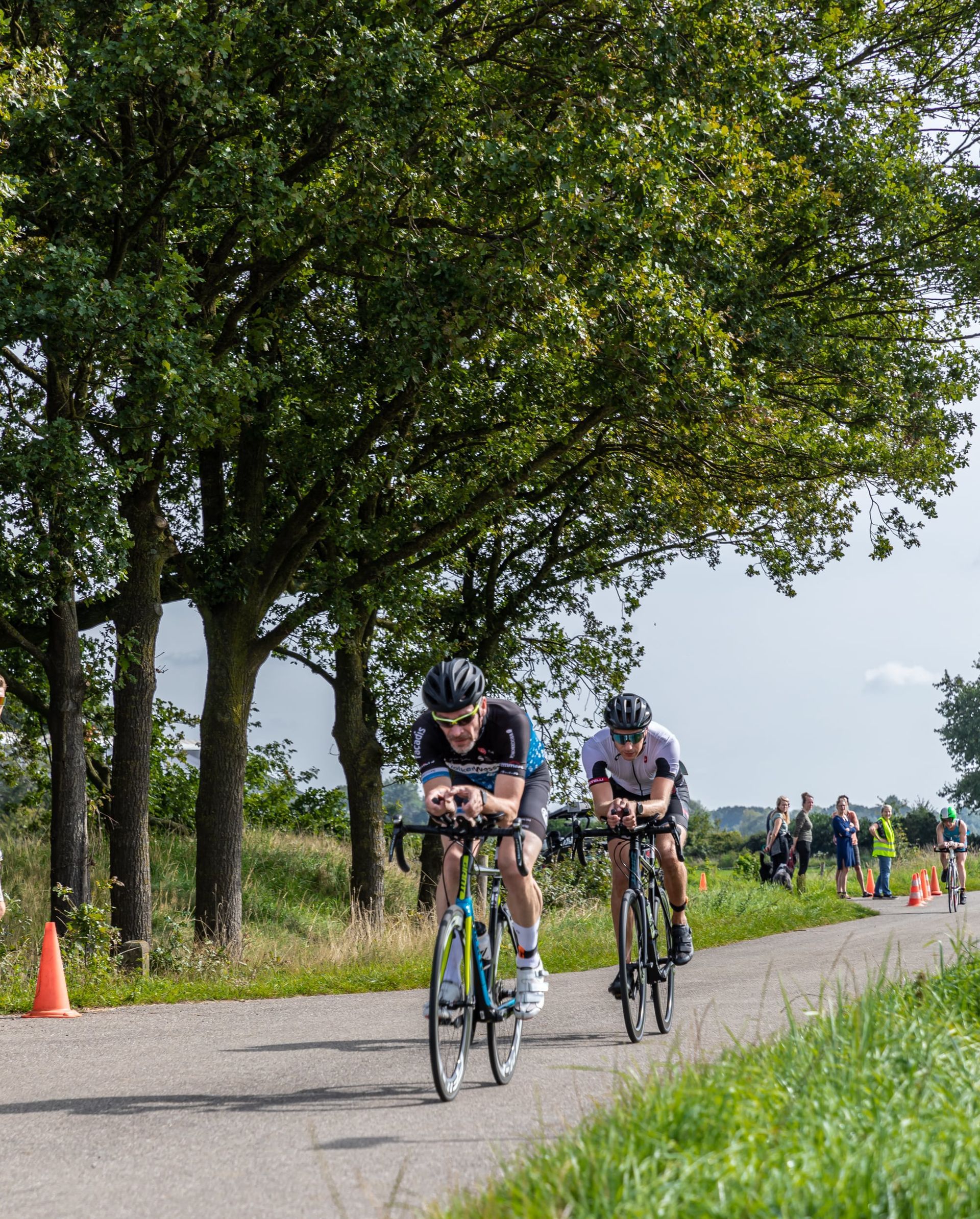 Een groep mensen fietst over een weg.