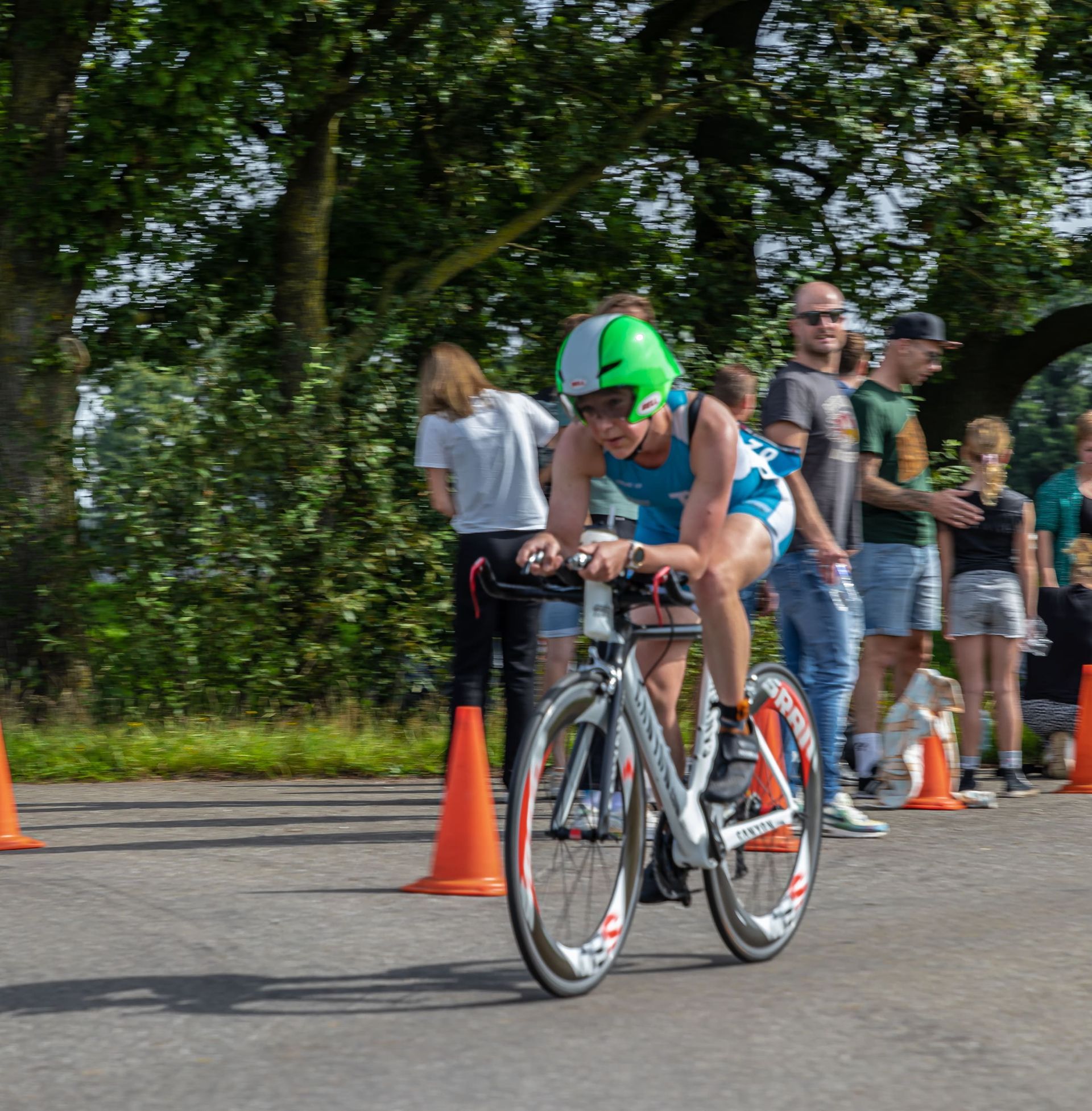Een persoon met een groene helm rijdt op een fiets