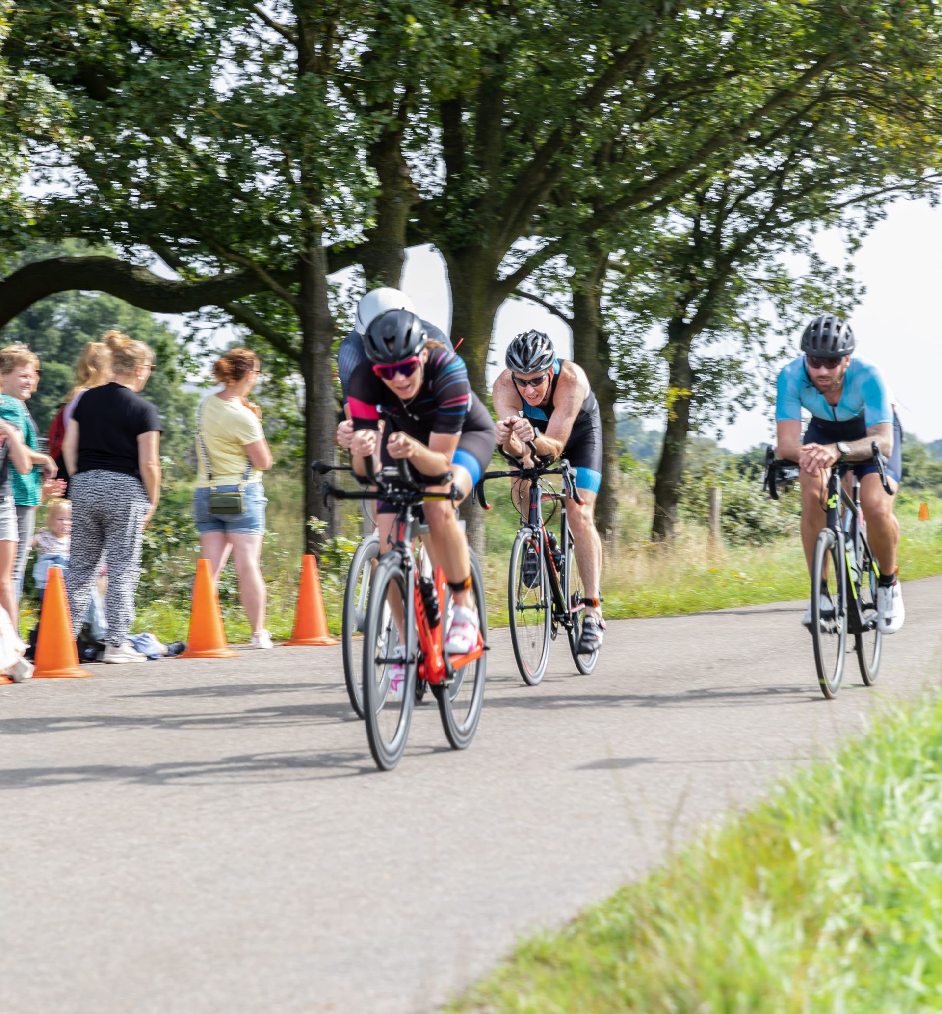 Een groep mensen fietst over een weg.