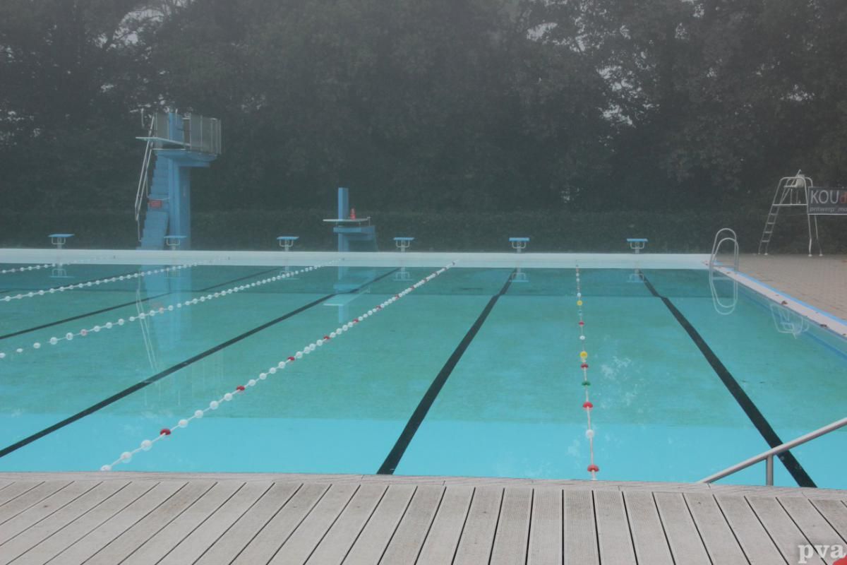 Triathlon Eibergen. Een leeg zwembad met een duikplank op de achtergrond
