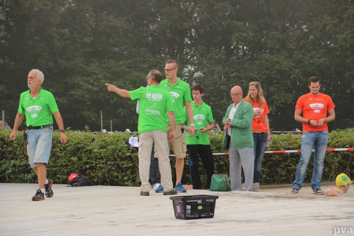 Triathlon Eibergen. Een groep mensen in groene shirts staat rond een mand.