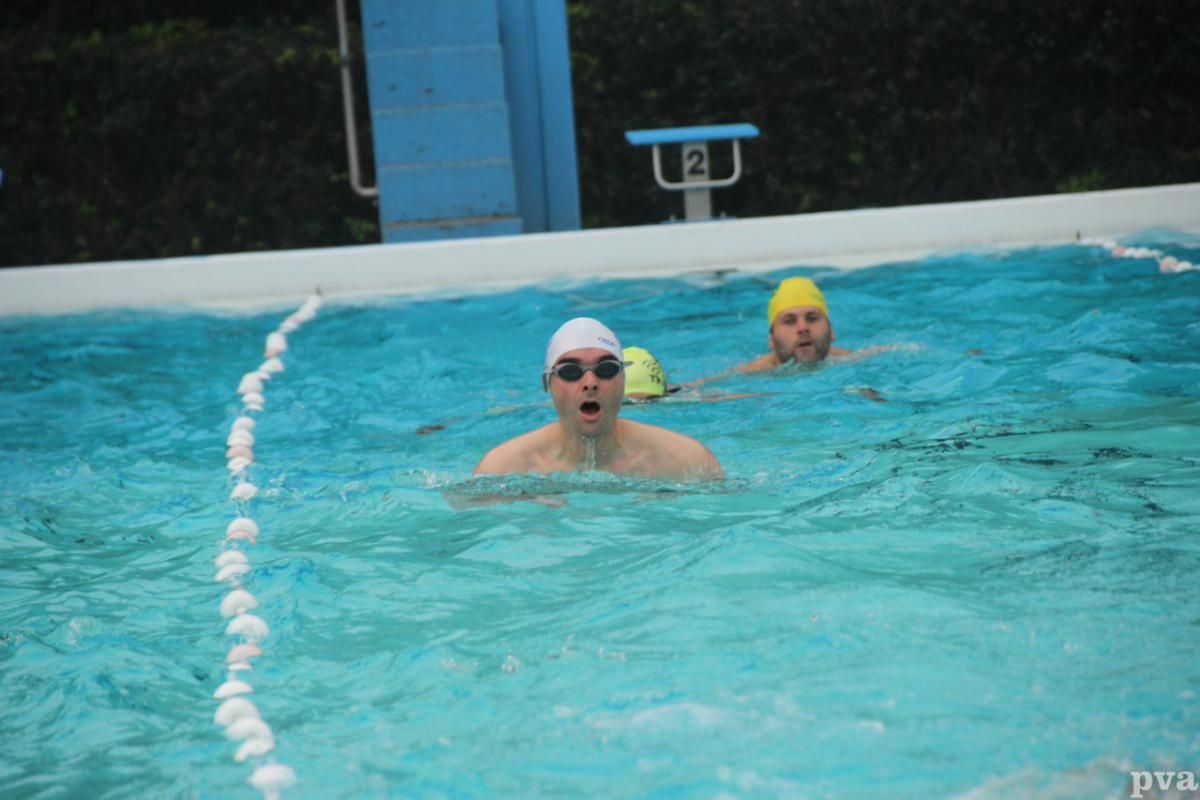 Triathlon Eibergen. Twee mannen zwemmen in een zwembad met het nummer 2 op de achtergrond