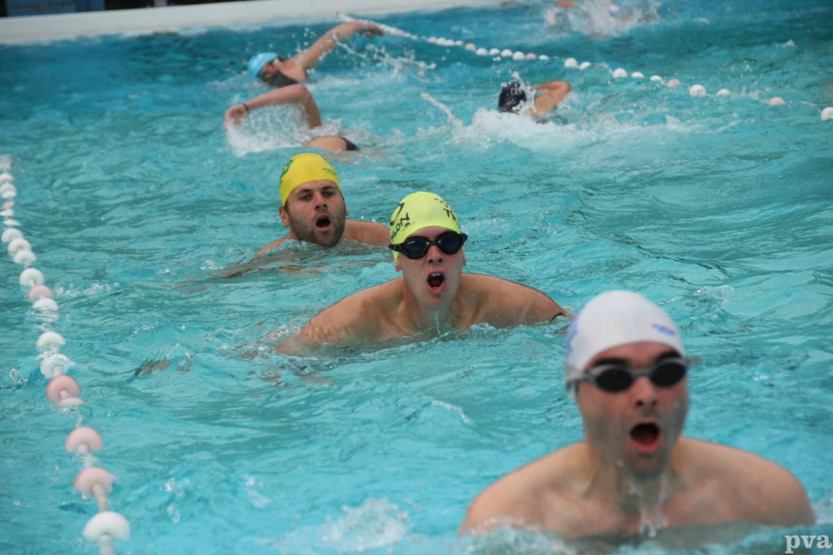 Triathlon Eibergen. Een groep mensen zwemt in een zwembad.