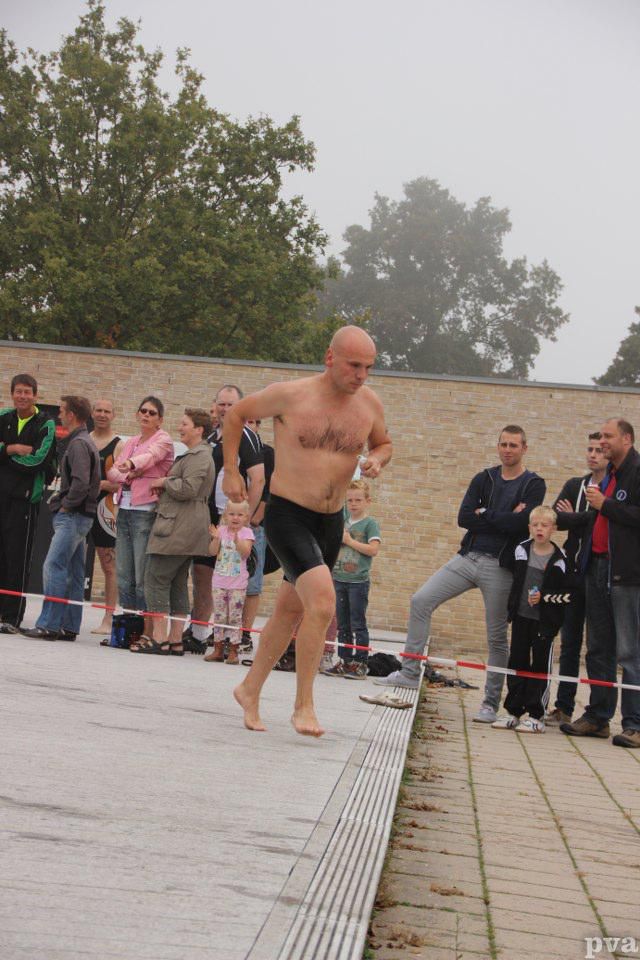 Triathlon Eibergen. Een man zonder shirt rent voor een menigte