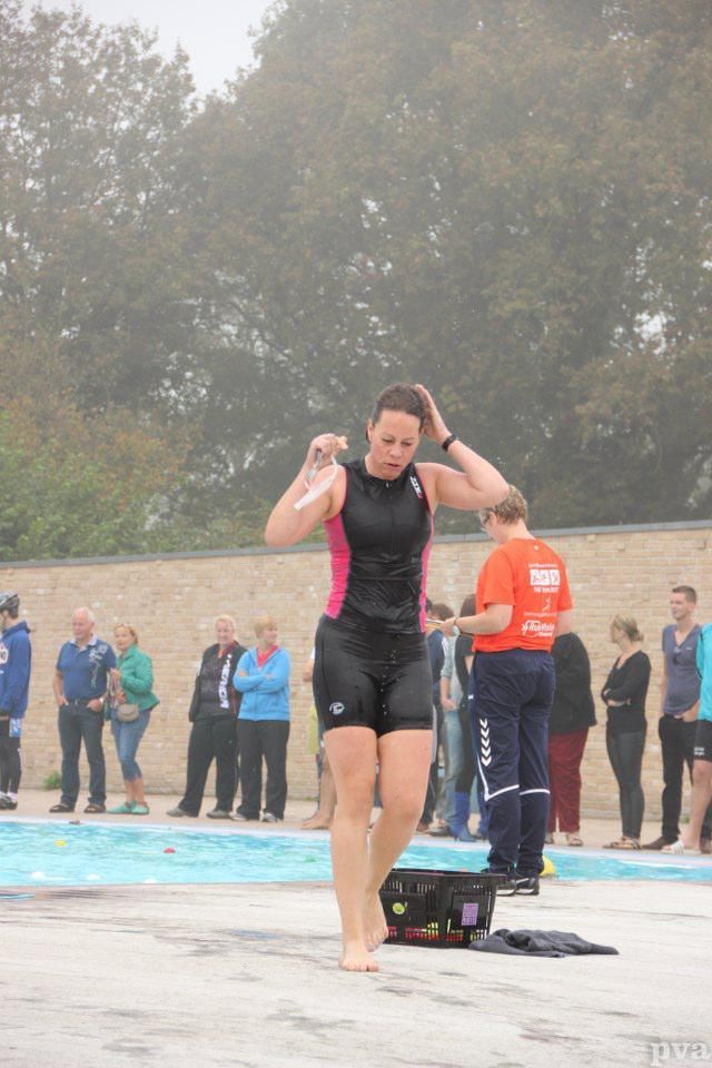 Triathlon Eibergen. Een vrouw in een wetsuit staat voor een zwembad.