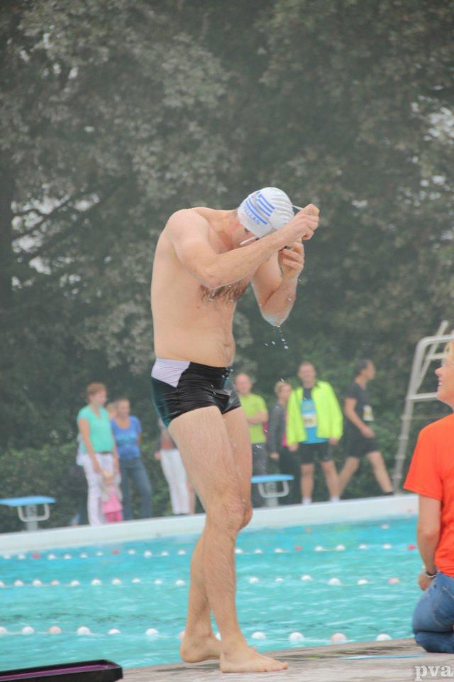 Triathlon Eibergen. Een man zonder shirt staat op de rand van een zwembad.