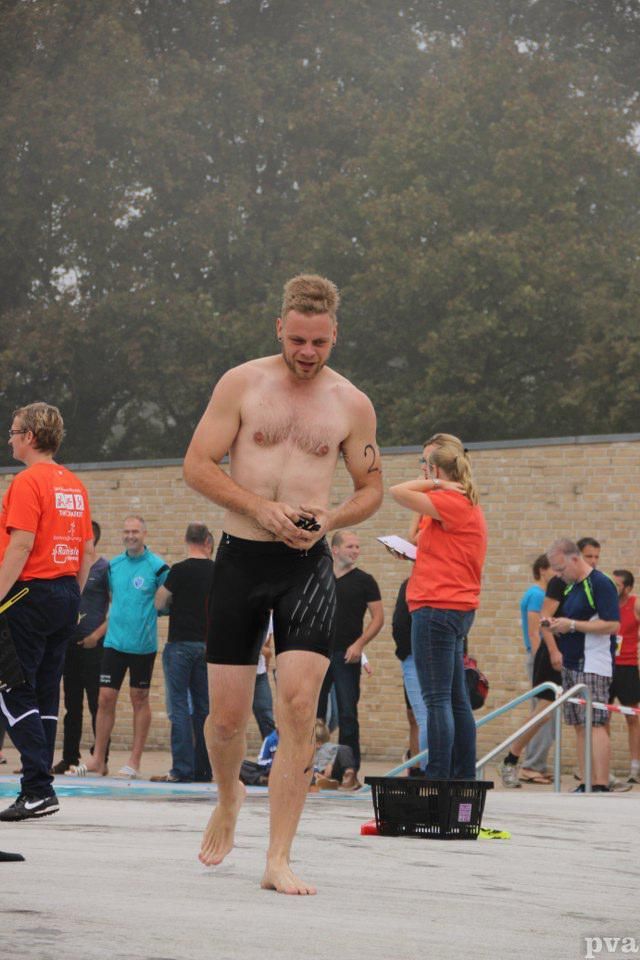 Triathlon Eibergen. Een man zonder shirt staat voor een groep mensen.