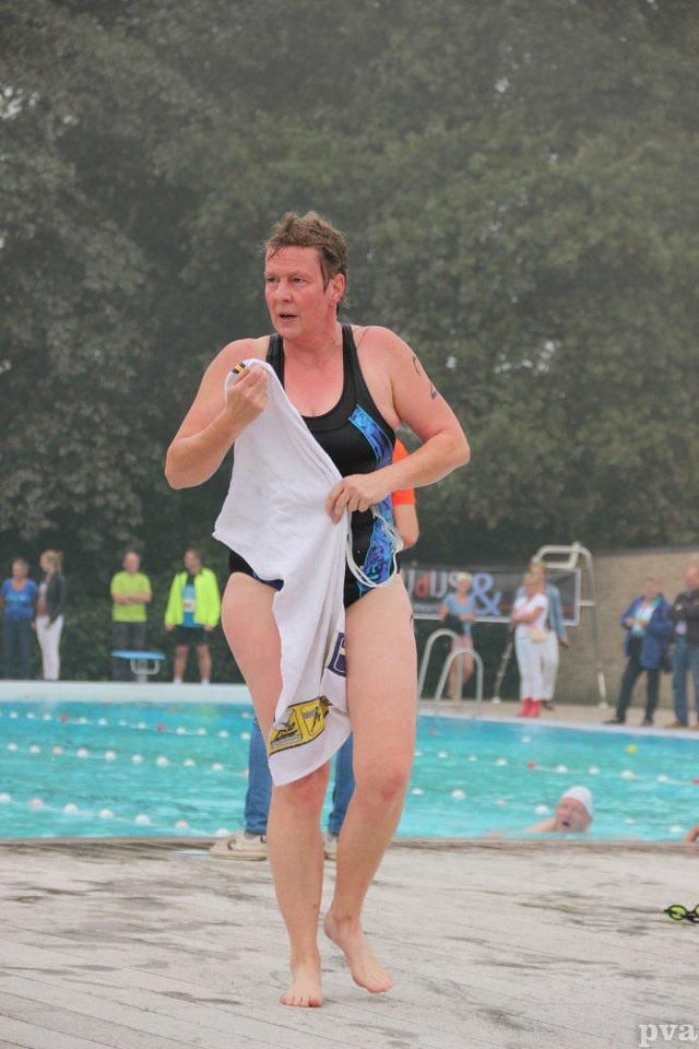Triathlon Eibergen. Een vrouw in badpak loopt naar een zwembad.