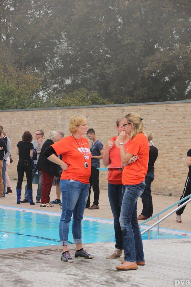 Triathlon Eibergen. Een groep mensen staat rond een zwembad.