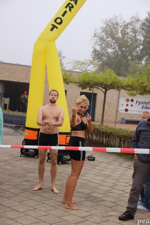 Triathlon Eibergen. Een man en een vrouw staan ​​voor een gele opblaasbare boot met het woord dak erop