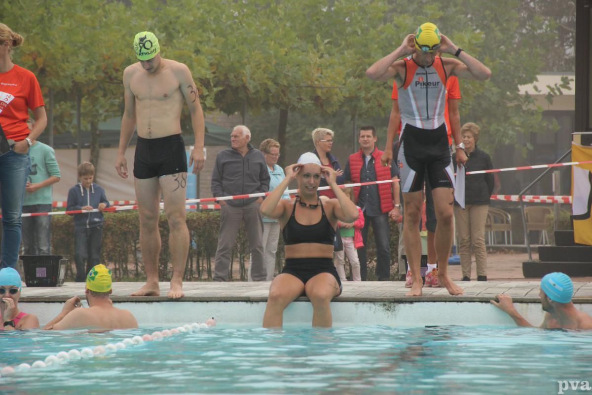 Triathlon Eibergen. Een vrouw zit op de rand van een zwembad