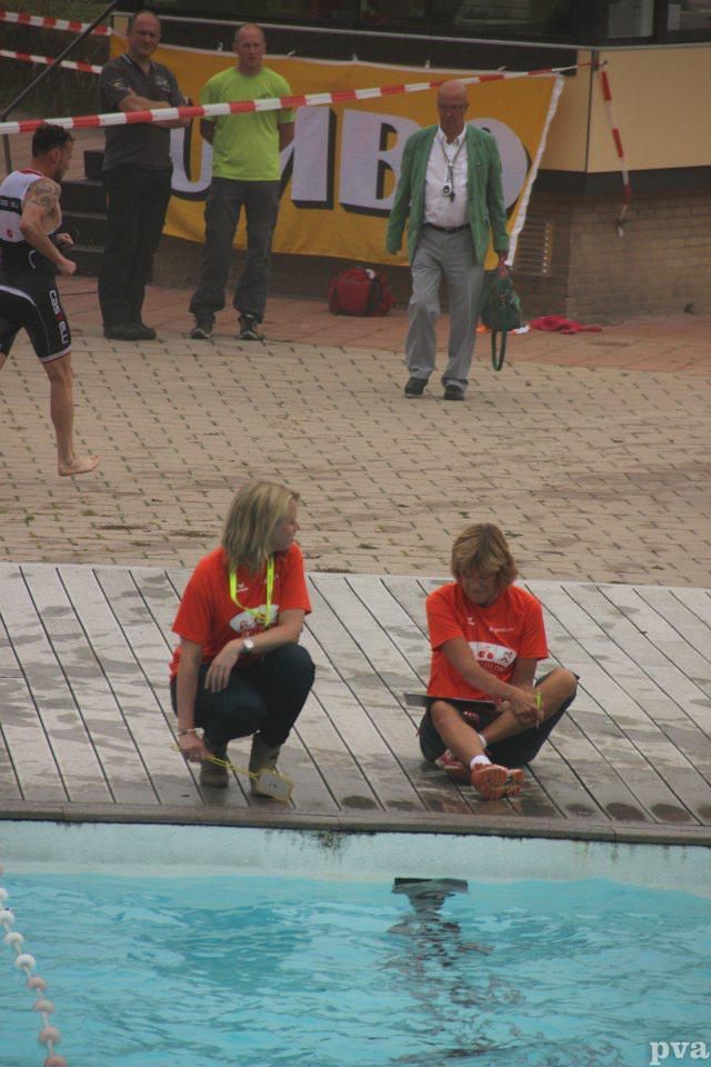 Triathlon Eibergen. Twee mensen hurken op de rand van een zwembad