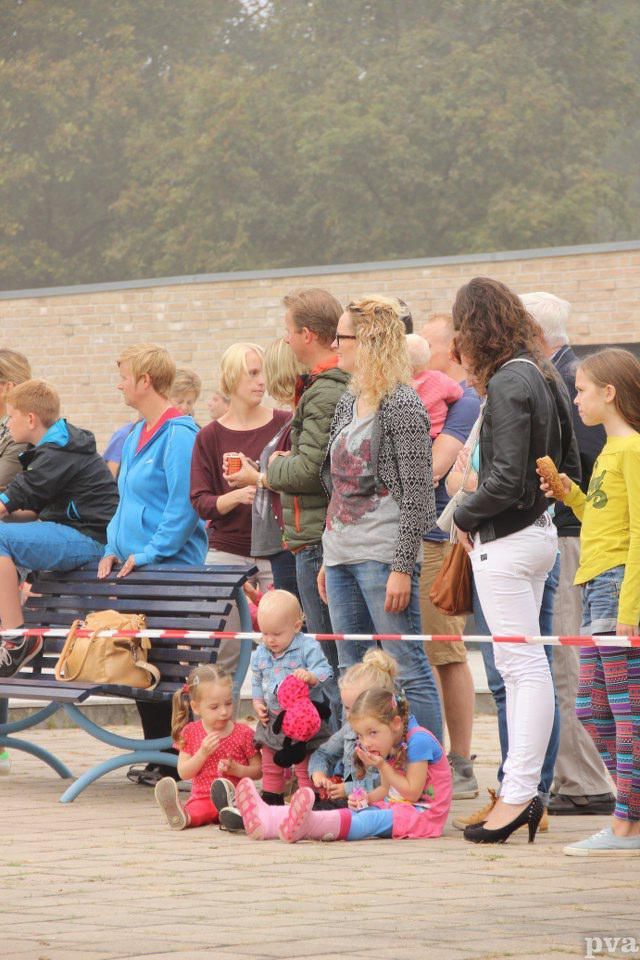 Triathlon Eibergen. Een groep mensen zit op banken en op de grond.