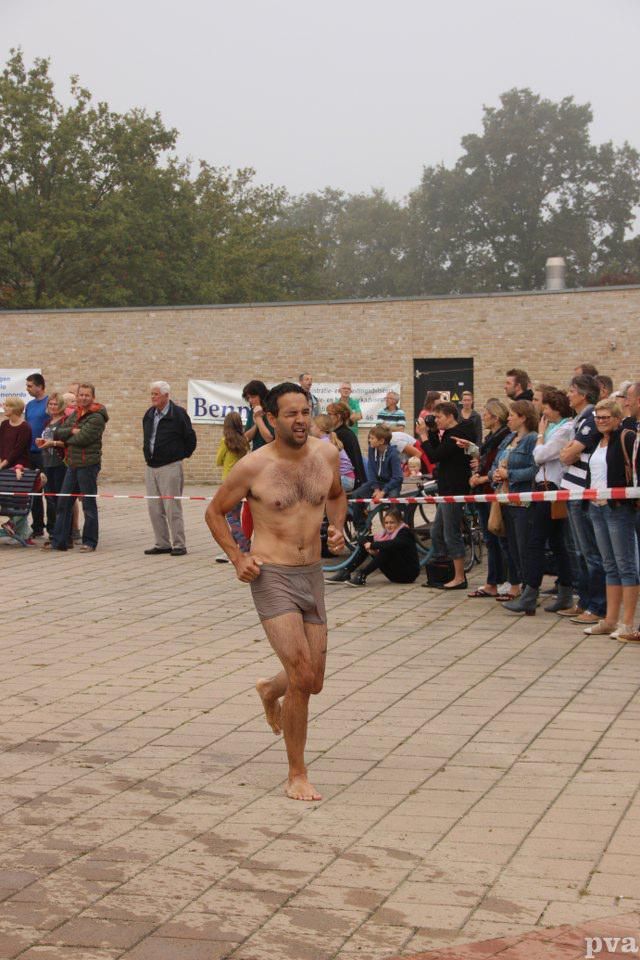 Triathlon Eibergen. Een man zonder shirt rent voor een menigte uit.