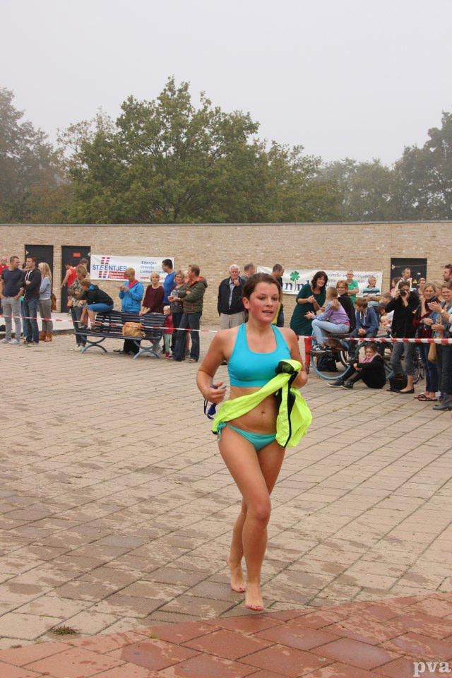 Triathlon Eibergen. Een vrouw in bikini rent voor een menigte uit.