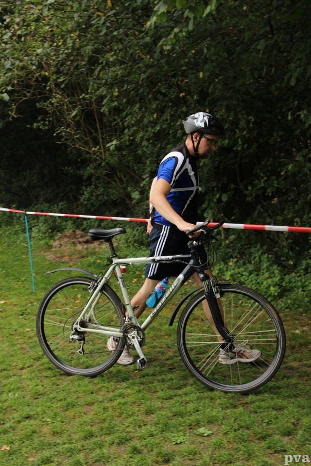 Triathlon Eibergen. Een man fietst op een grasveld.