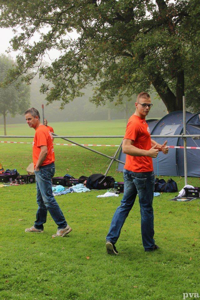 Triathlon Eibergen. Twee mannen staan ​​in een veld met op de achtergrond een tent.