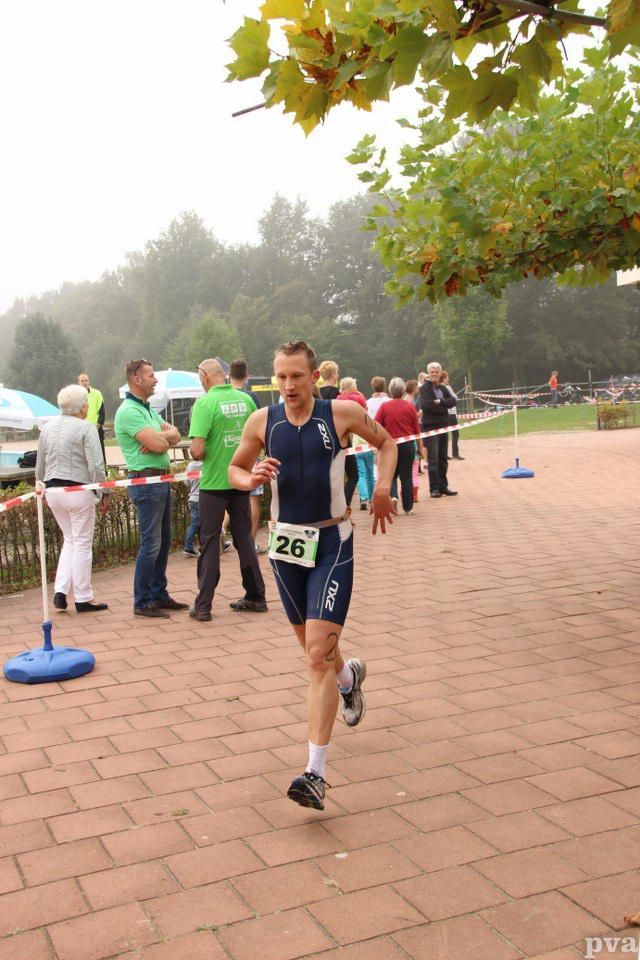 Triathlon Eibergen. Een man doet mee aan een race met nummer 26 op zijn shirt.