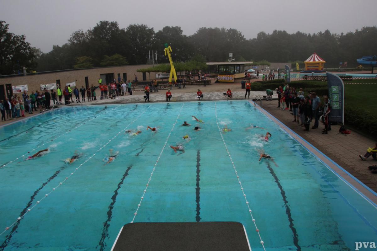 Triathlon Eibergen. Een groep mensen zwemt in een groot zwembad.