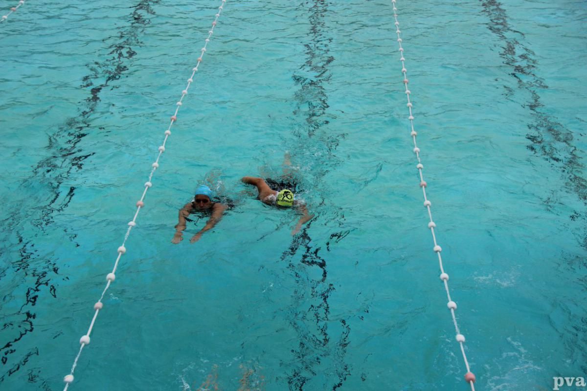 Triathlon Eibergen. Twee mensen zwemmen in een zwembad.