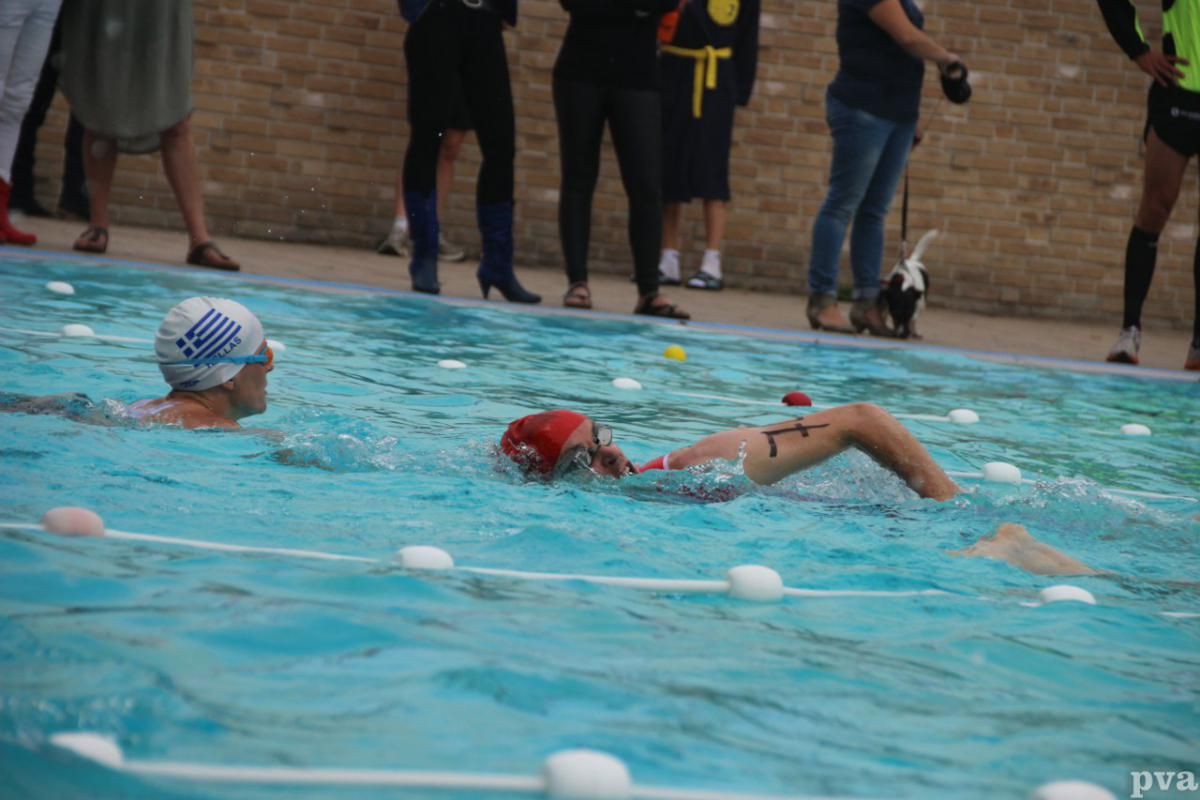 Triathlon Eibergen. Twee mensen zwemmen in een zwembad en één heeft een tatoeage op zijn been
