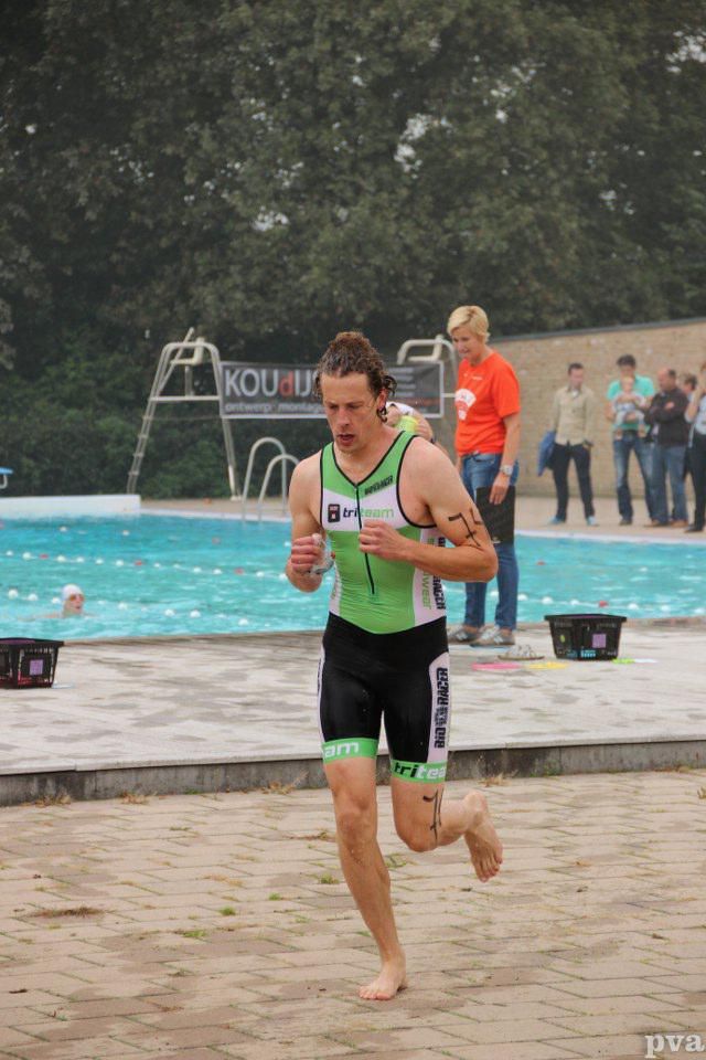 Triathlon Eibergen. Een man rent voor een zwembad.