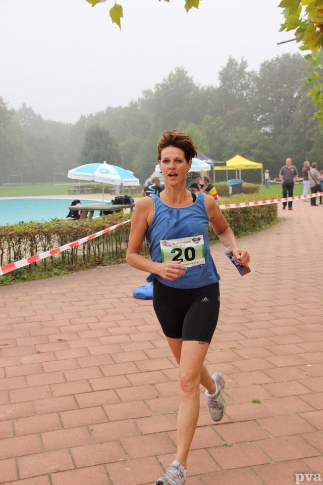 Een vrouw doet mee aan een race met het nummer 20 op haar shirt.