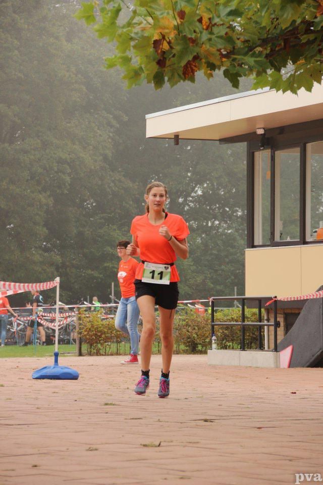 Een vrouw doet mee aan een wedstrijd met nummer 11 op haar startnummer.