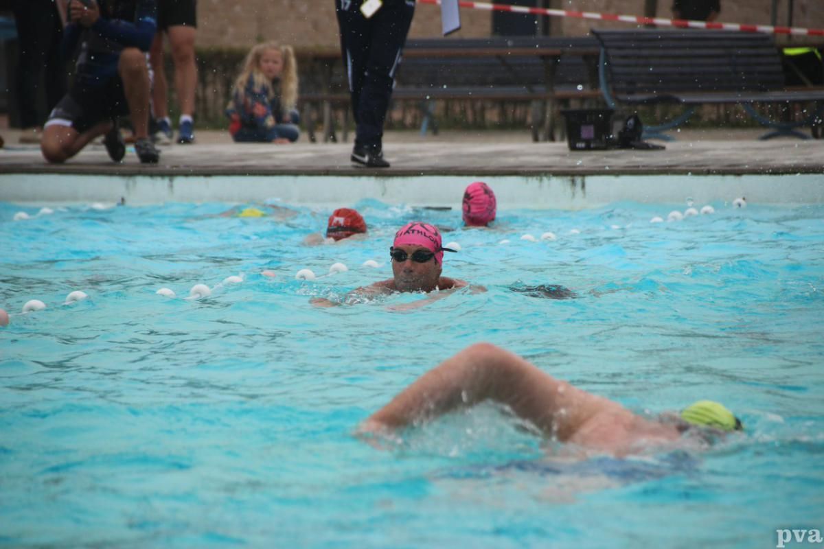 Een groep mensen zwemt in een zwembad.