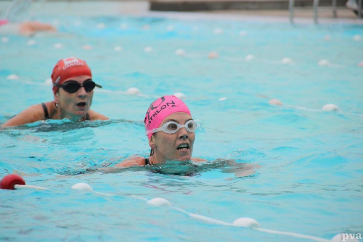 Twee vrouwen zwemmen in een zwembad.