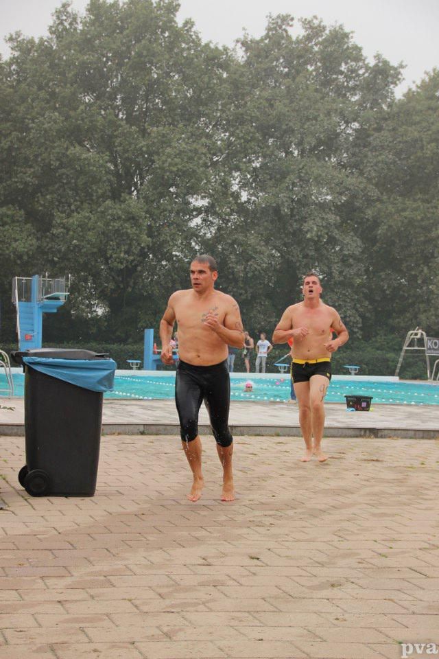 Twee mannen rennen voor een zwembad.