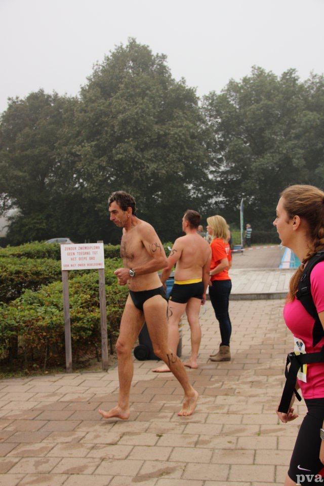 Een groep mensen loopt op een stoep van bakstenen.