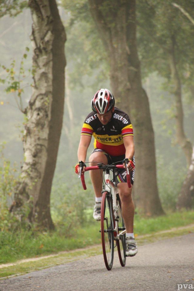 Een man fietst over een mistige weg.