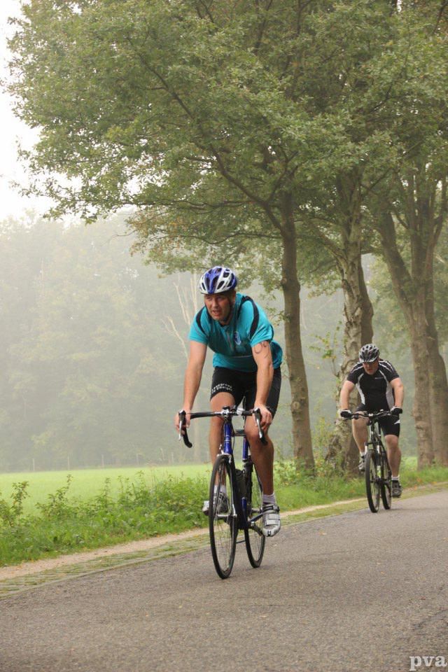 Triathlon Eibergen. Twee mannen fietsen over een weg.