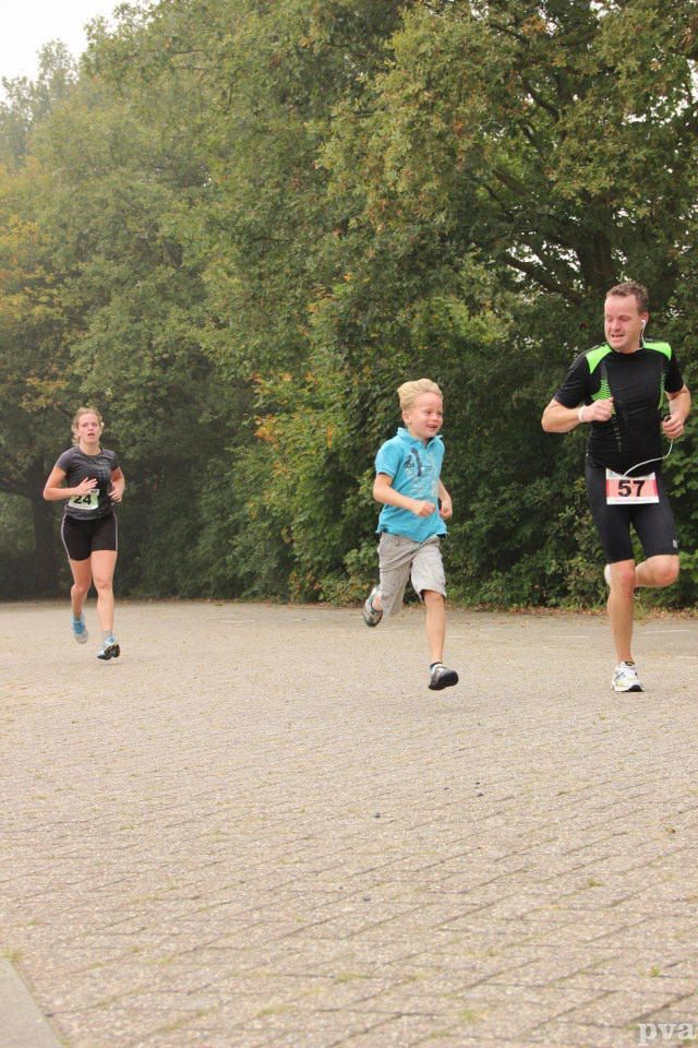 Triathlon Eibergen. Een groep mensen rent over een stenen weg.