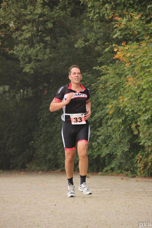 Triathlon Eibergen. Een man rent mee aan een race met het nummer 33 op zijn riem.