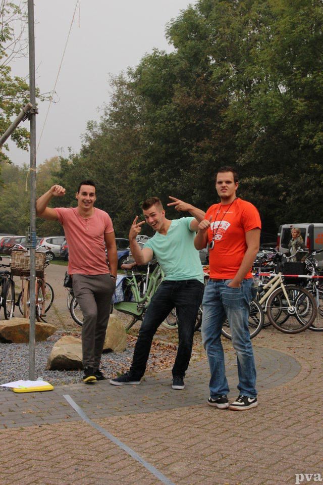 Triathlon Eibergen. Drie mannen poseren voor een foto op een parkeerplaats met fietsen.