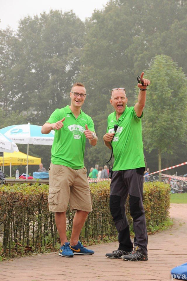Triathlon Eibergen. Twee mannen in groene shirts staan ​​naast elkaar op de stoep.