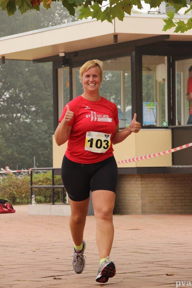 Een vrouw rent met het nummer 103 op haar shirt