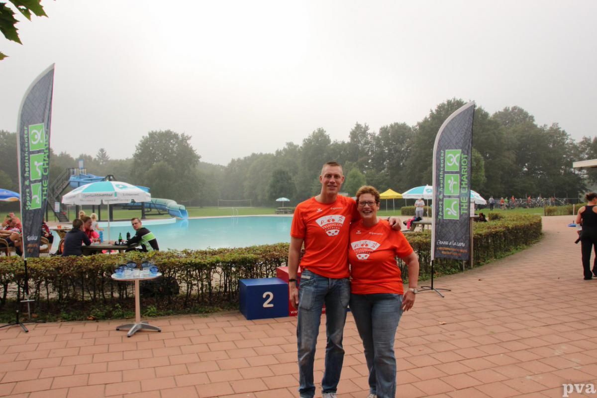 Een man en een vrouw poseren voor een foto voor een zwembad.