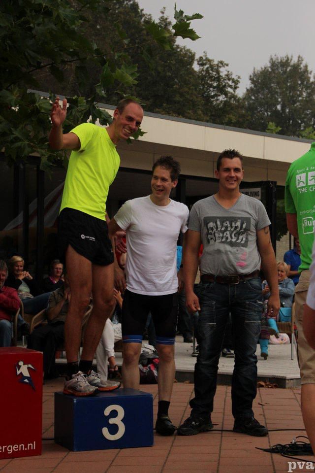 Drie mannen staan ​​op een podium met het nummer 3 erop