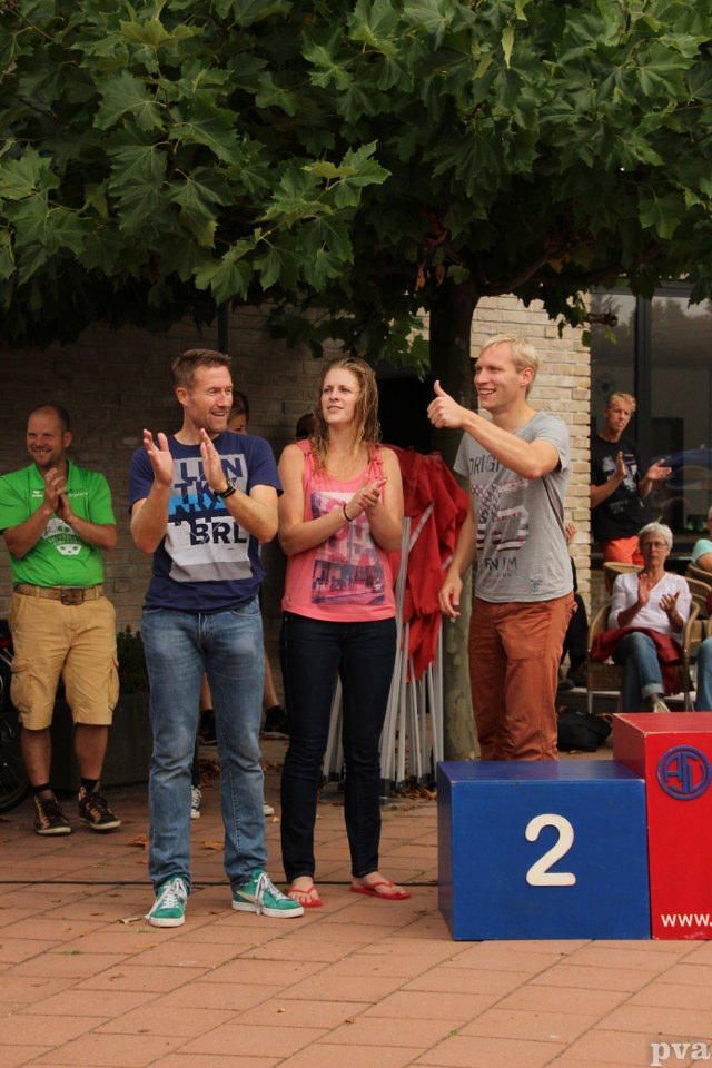 Een groep mensen die rond een podium staan ​​met het cijfer 2 erop.