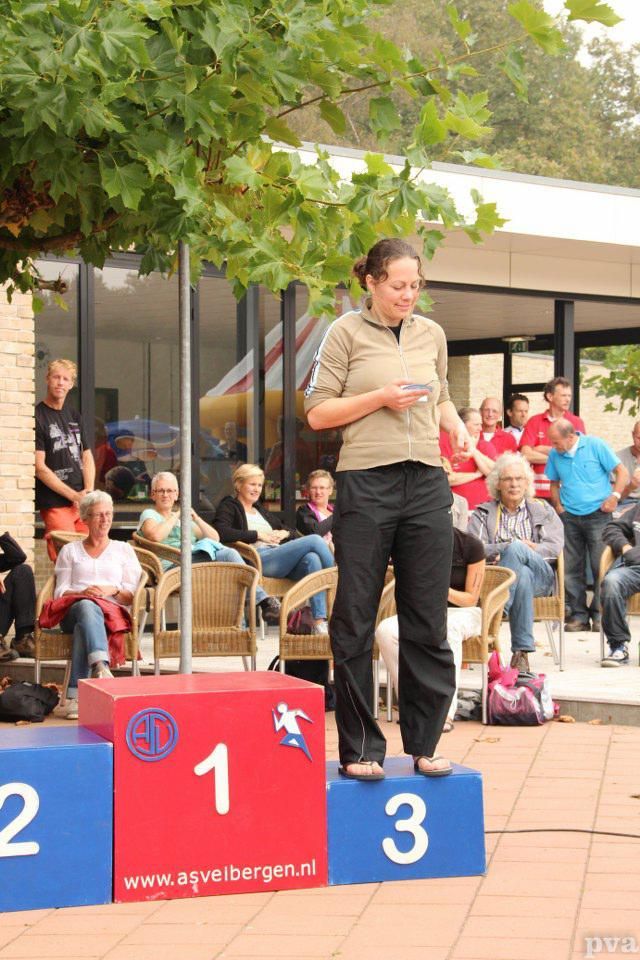 Een vrouw staat op een podium voor een menigte mensen.