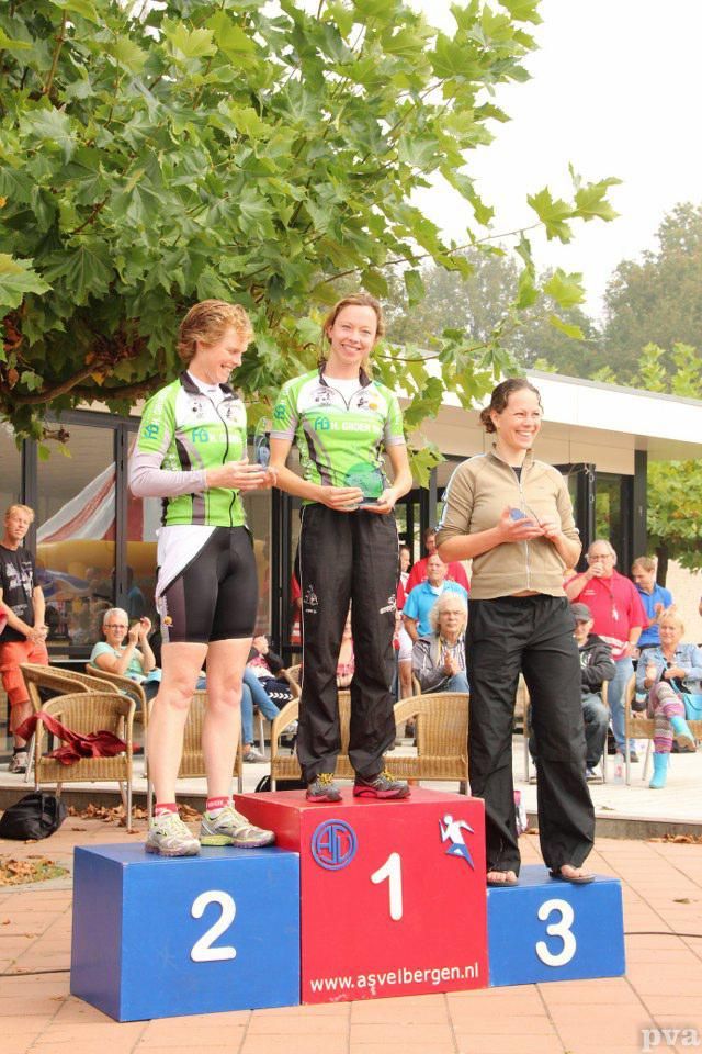 Drie vrouwen staan ​​op een podium met de nummers 1, 2 en 3 erop