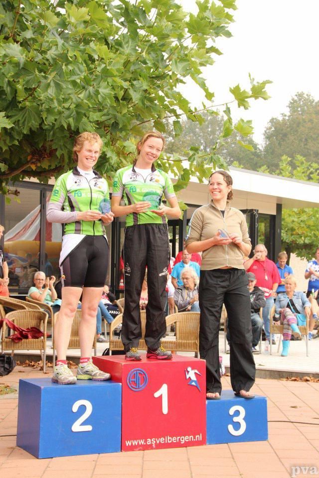 Drie vrouwen staan ​​op een podium met de nummers 1, 2 en 3