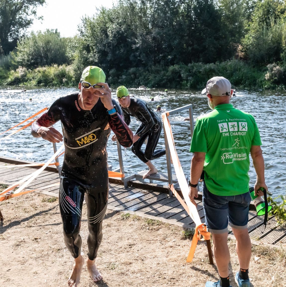 Een man in een groen shirt met de tekst 'triatlon' erop