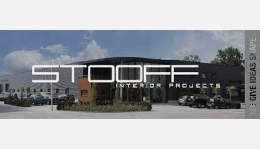 Een bord voor stooff interieurprojecten met een gebouw op de achtergrond