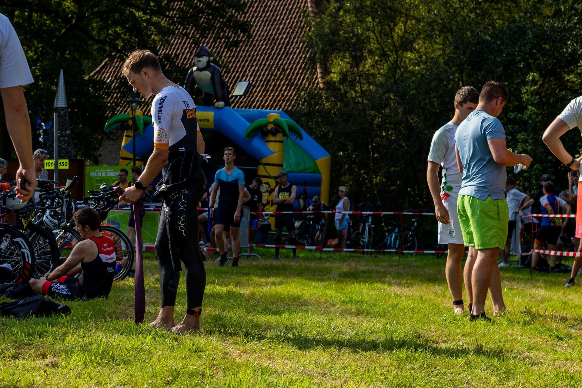 Een groep mensen staat in een veld met op de achtergrond een springkussen.