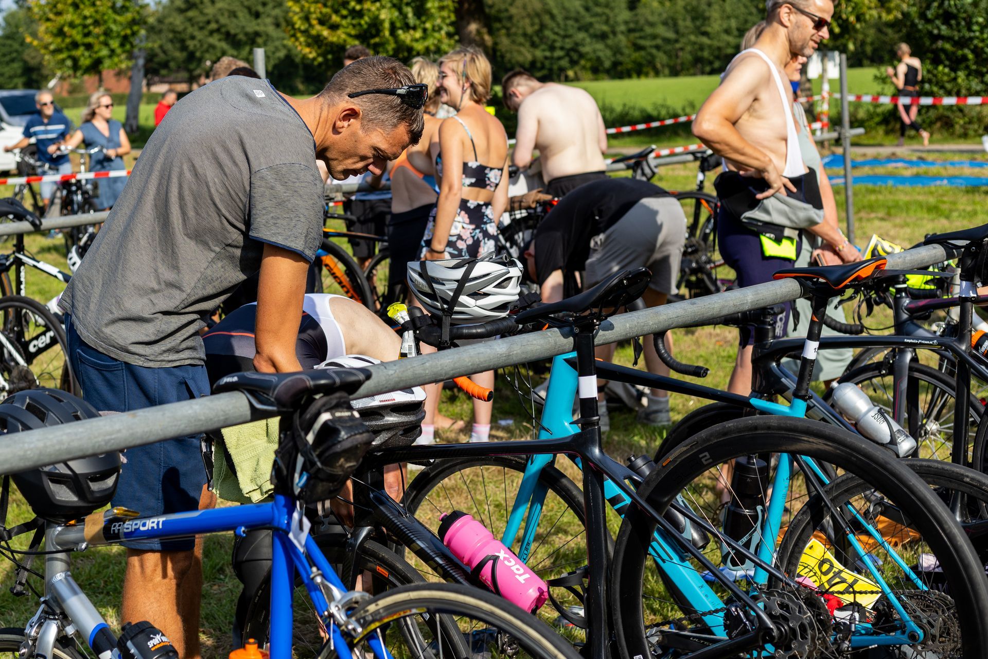 Een man staat naast een rij fietsen.