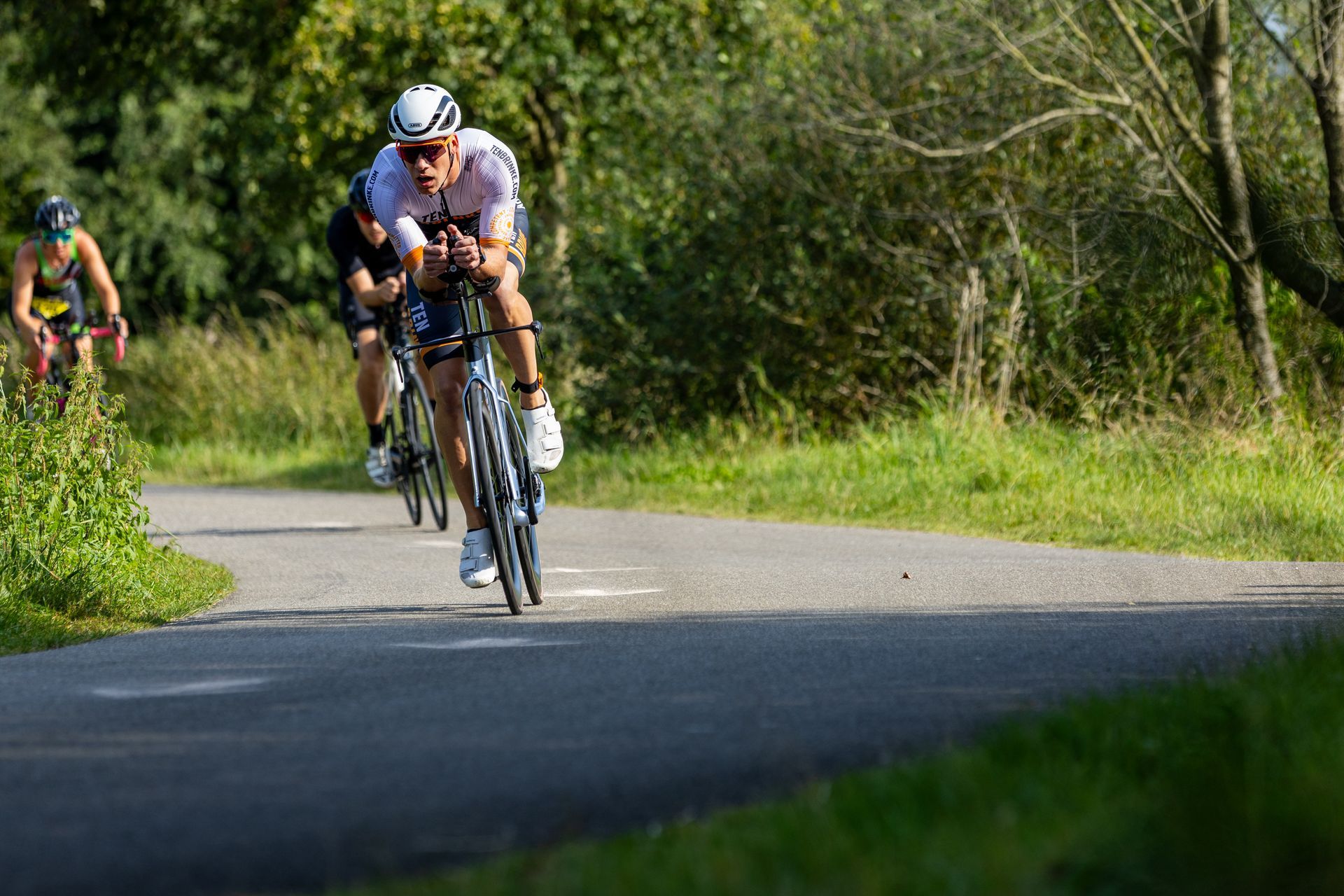 Een groep mensen fietst over een weg.